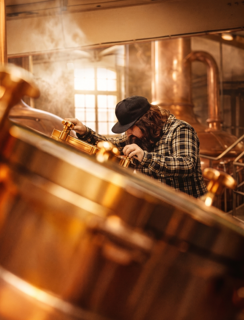 Brouwer die in de brouwketel aan het kijken is in de gouverneur lindeboom brouwerij